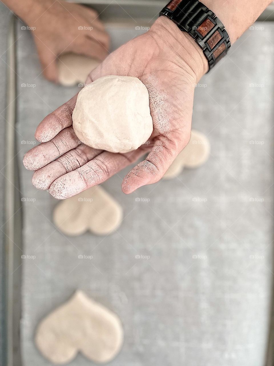 Woman’s hand holds dough while child steals cookie, cute cookie thief, mother and daughter bake together, having fun with Mommy, in the kitchen with mommy 