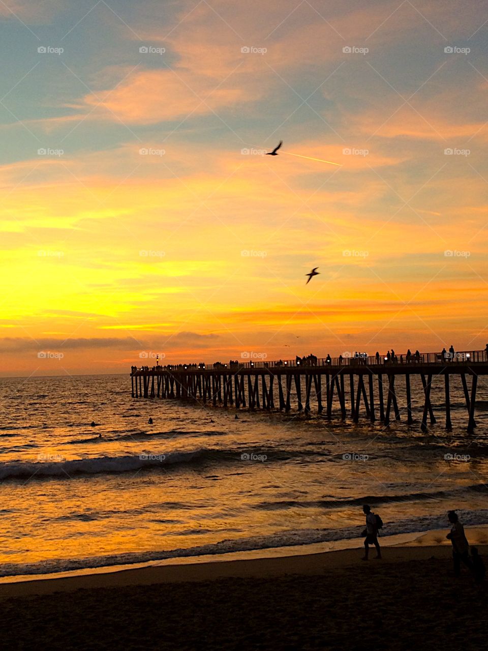 Silhouette of pier over sea during sunset