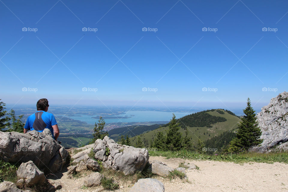 Rear view of man sitting on rock