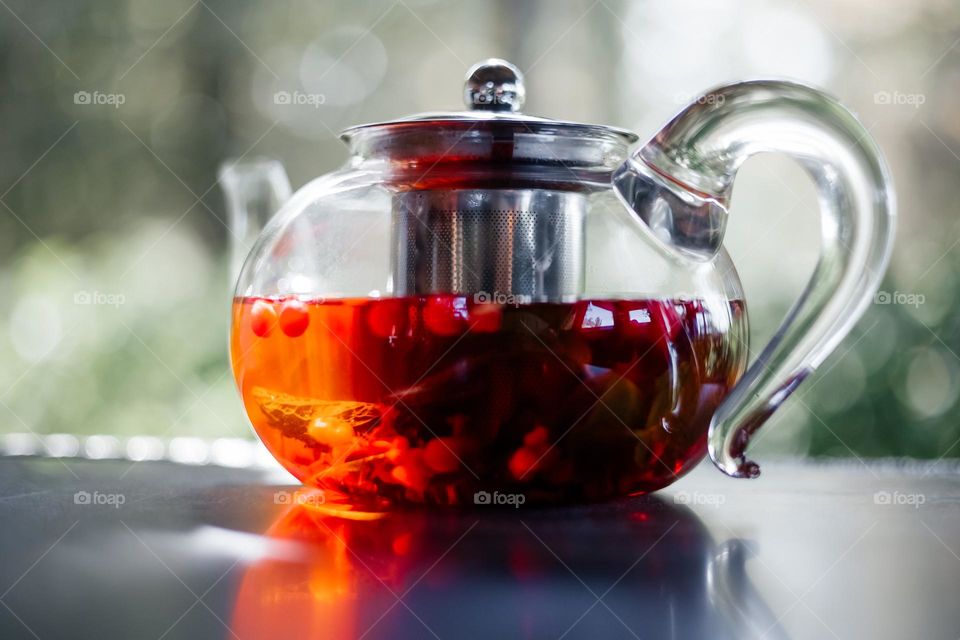 Glass teapot with hot red berry tea  , close-up