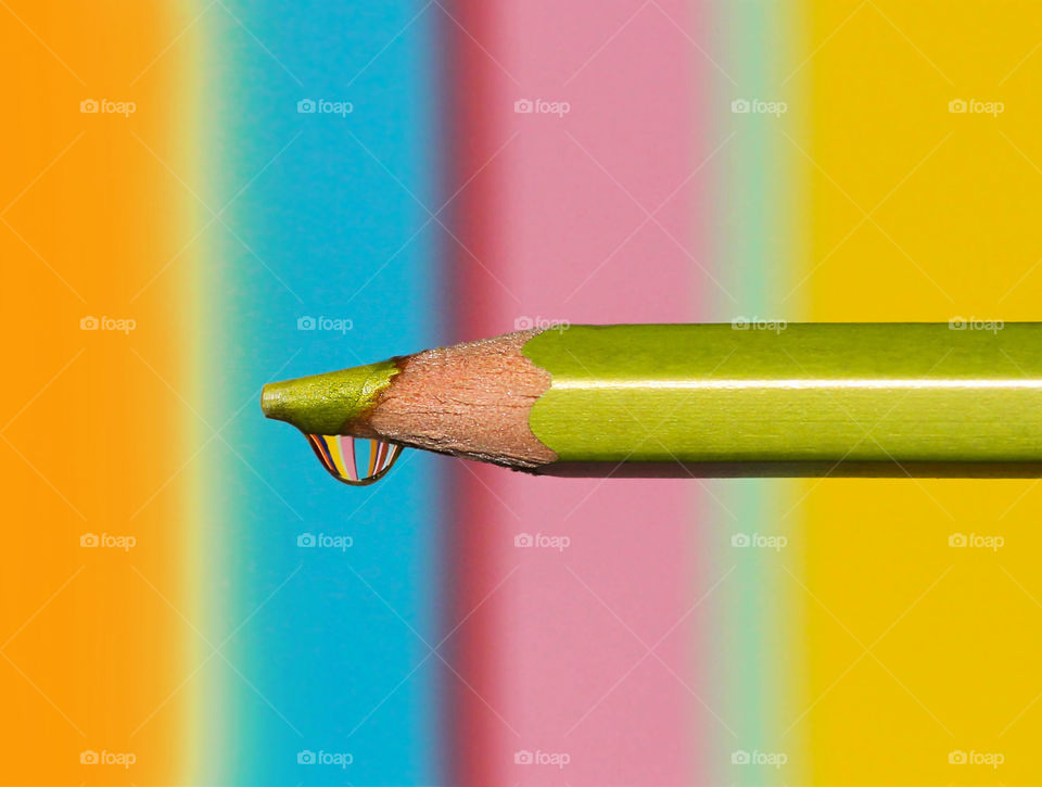 Colored pencil with water drop on the top, colorful reflection