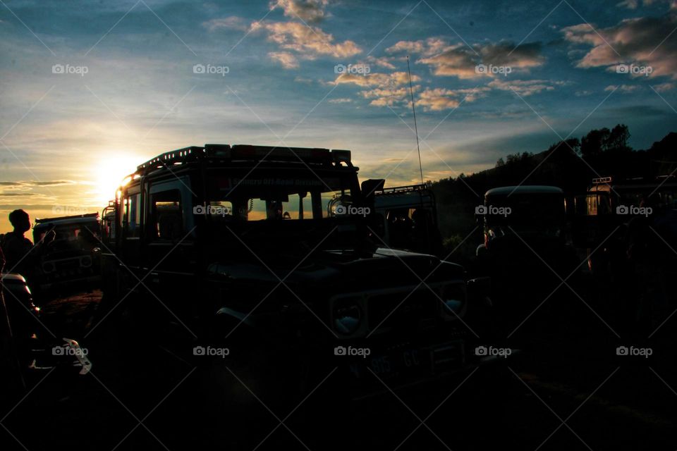 Sunrise that illuminates the car parking area on a hill in the Bromo mountains, East Java.