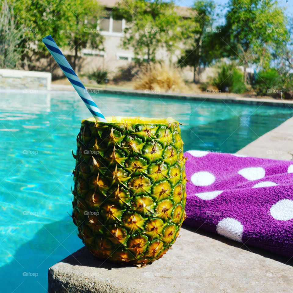 Enjoying a refreshing summery pineapple drink by the pool.