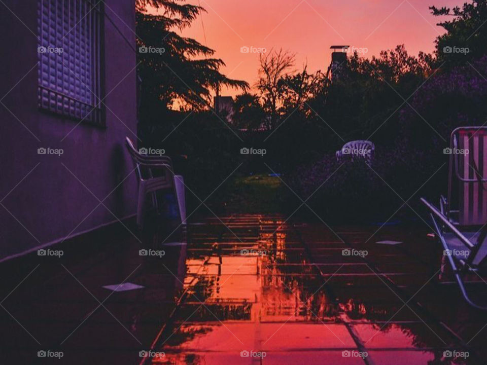 Aesthetic warm sunset photo, with the reflection of the sunset on a puddle beneath it🤩