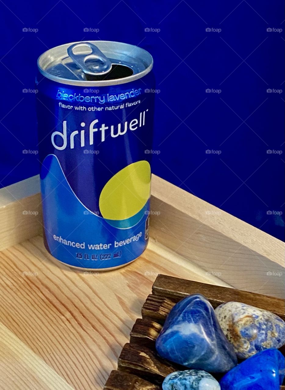 Driftwell beverage on a tray along with some colorful stones 