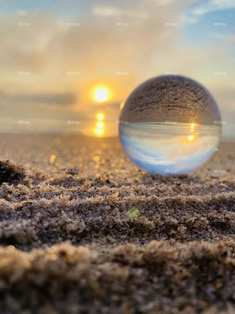 A gorgeous sunrise on the Florida coast with close up of sand and a lensball