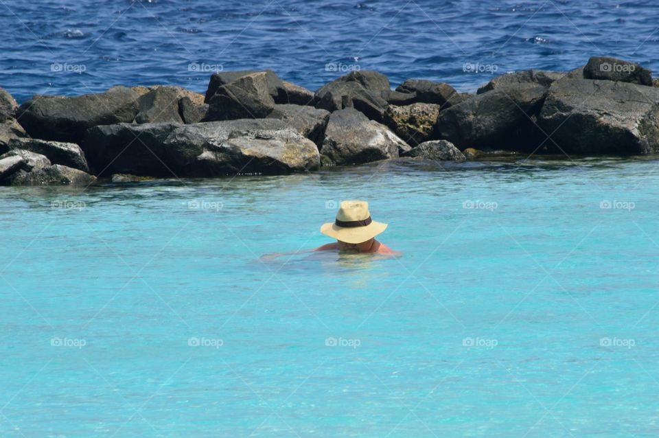 mister with hat in the blue sea
