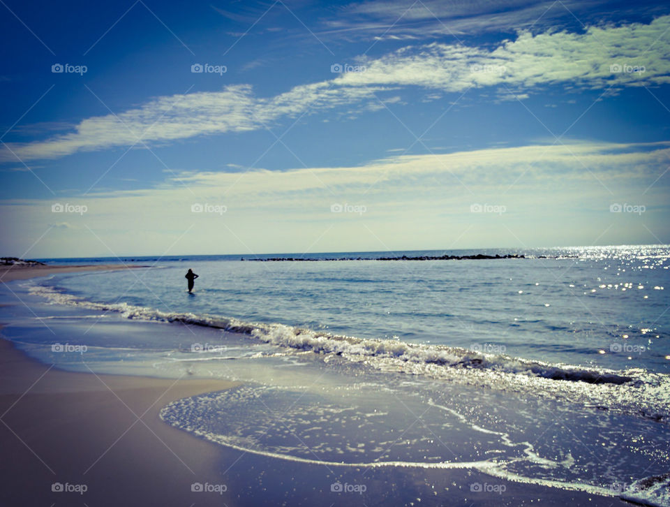 Woman walking lonely in the sea water.