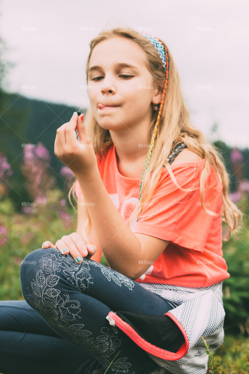 Blueberry picked in mountains. Girl looking at blueberry picked in mountains