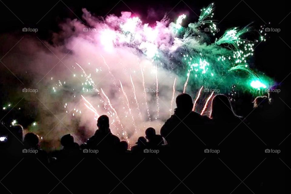 A group of people admire a colorful fireworks display