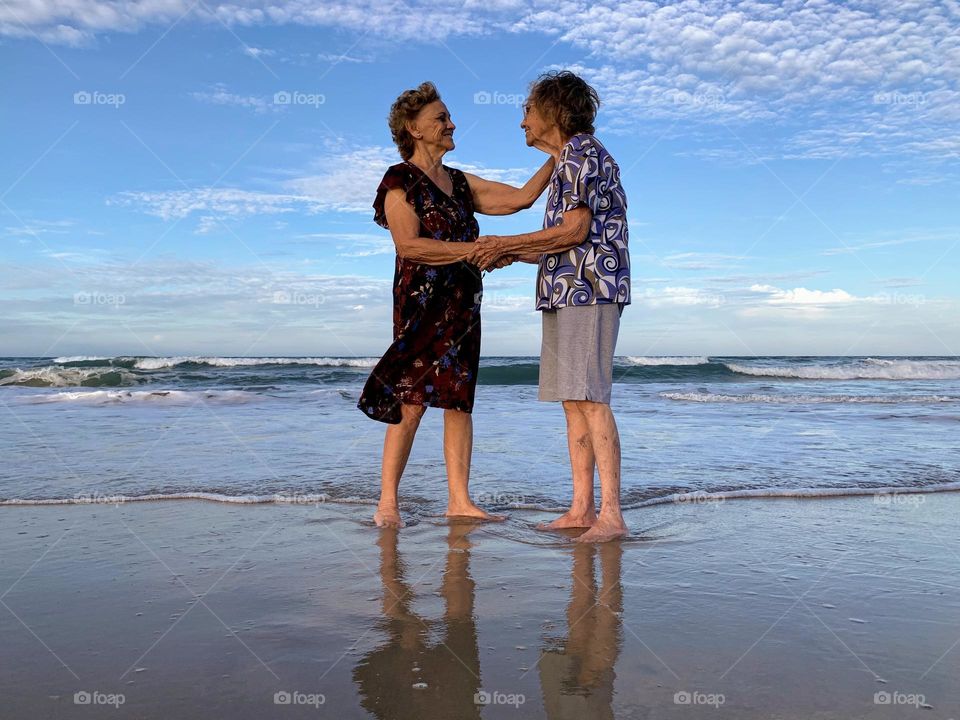 Two elderly sisters on the beach