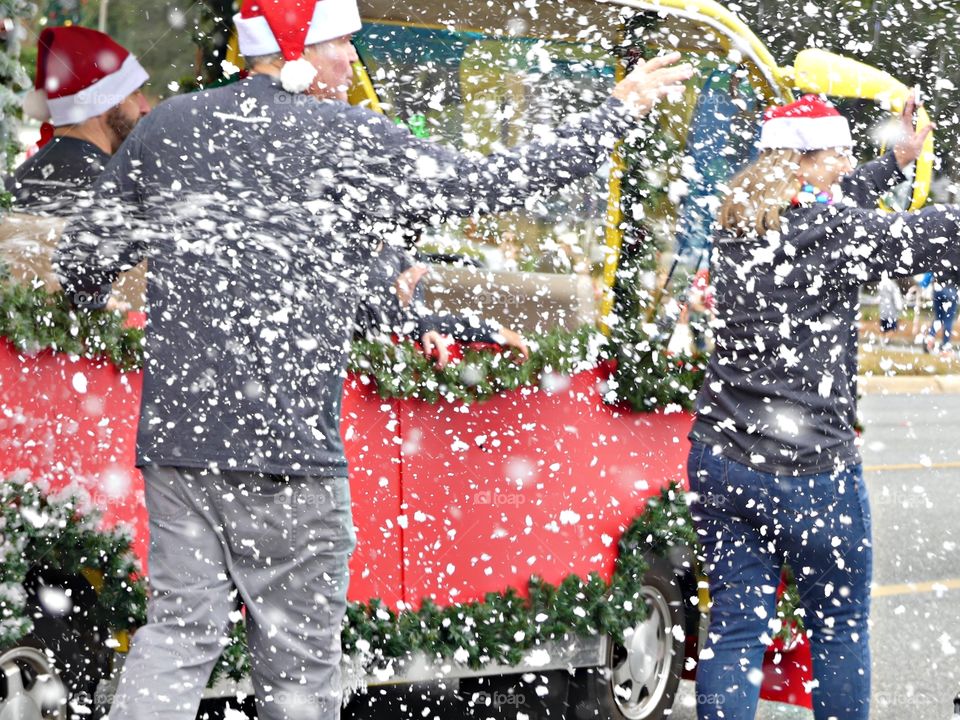 Artificial snowflakes are blow into the air to give it that Christmas winter look during the parade