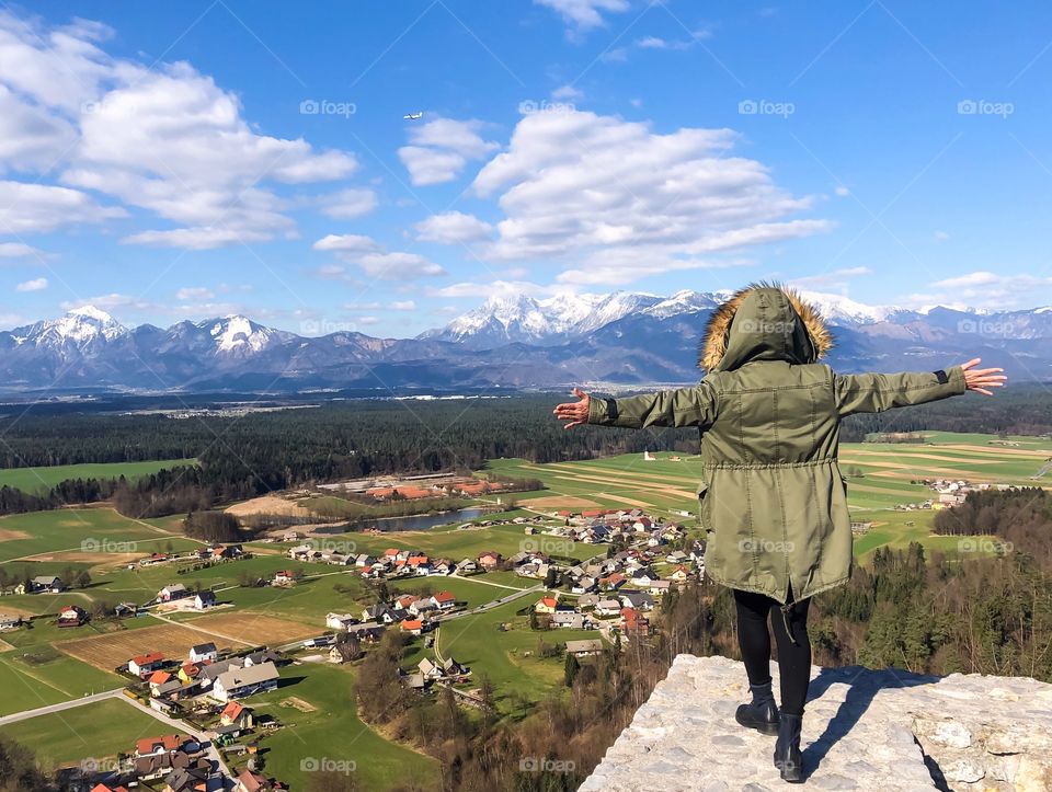 People from behind enjoying view of villages with mountains on back ground on sunny day in winter time 