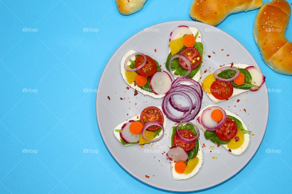 Mozzarella slices with vegetables on a blue background