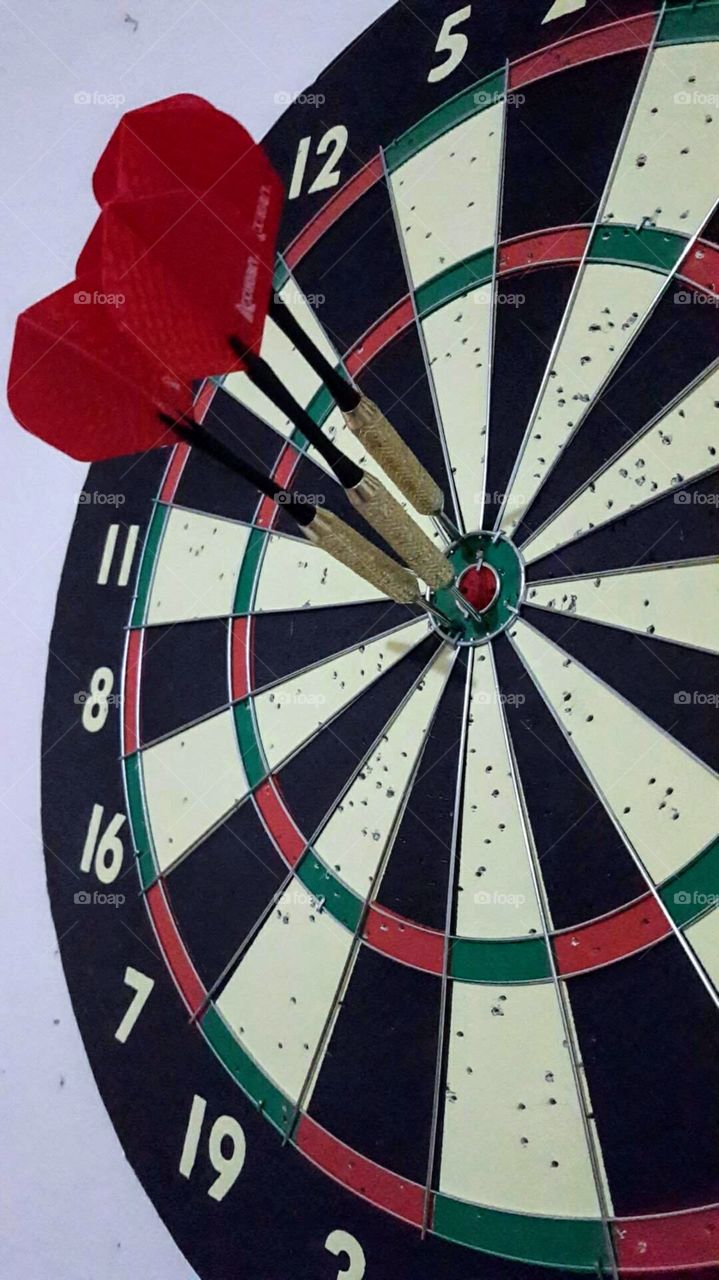 Playing darts with my husband and he makes three accurate shots in a row. The grouping is spot on!