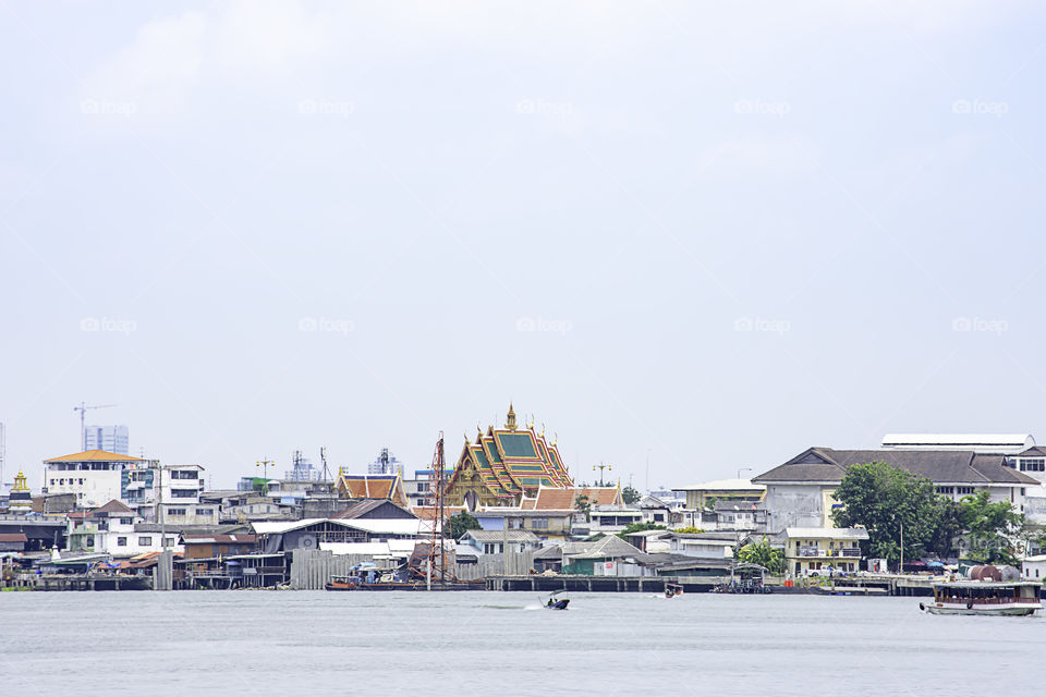 Ships crossing in Chao Phraya River and cityscape Background sky and clouds at Pak Kret in Nonthaburi , Thailand. April 16, 2019