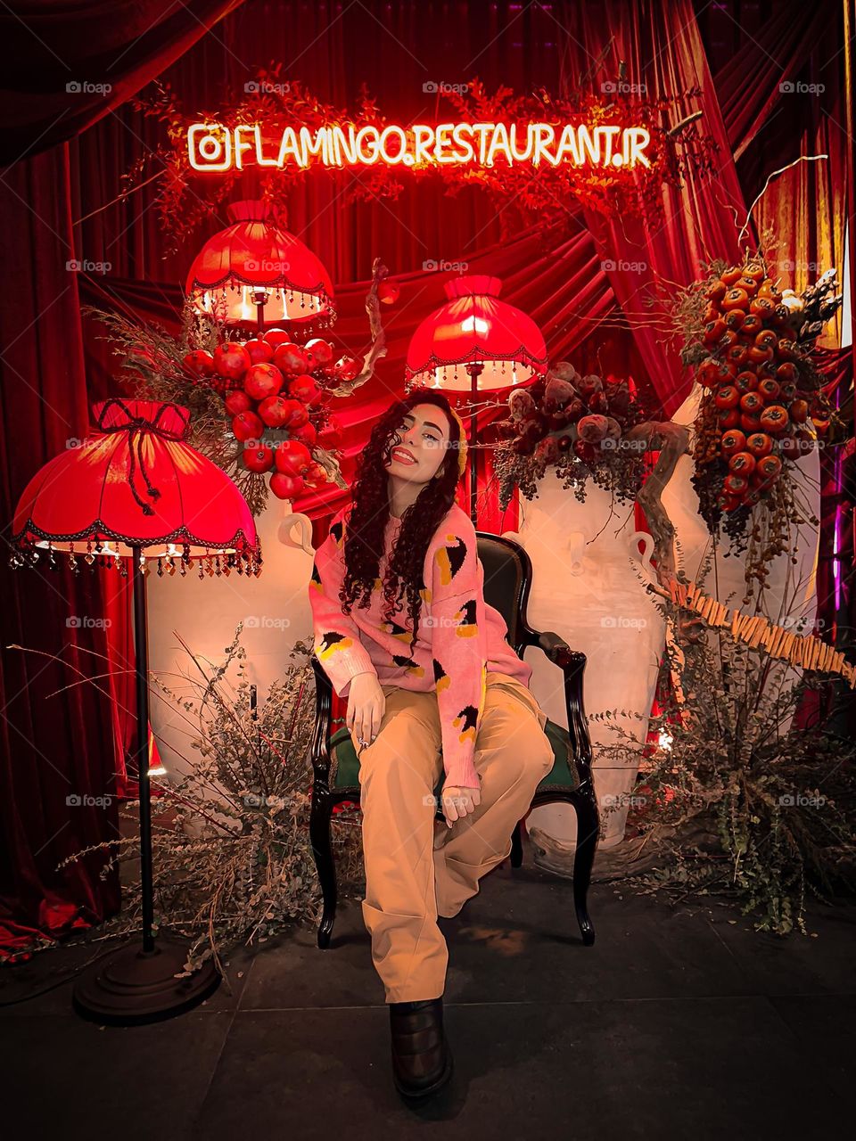 A girl with curly hair and clusters of pomegranates and persimmons