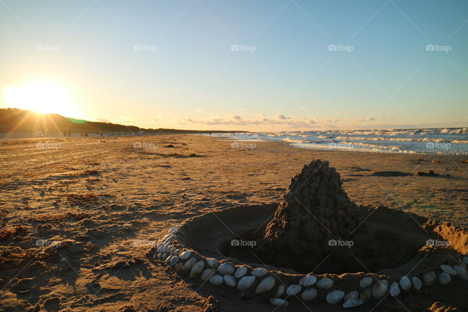 Sand castle with shells in the sunset on the beach of Karlshagen on the German island of Usedom