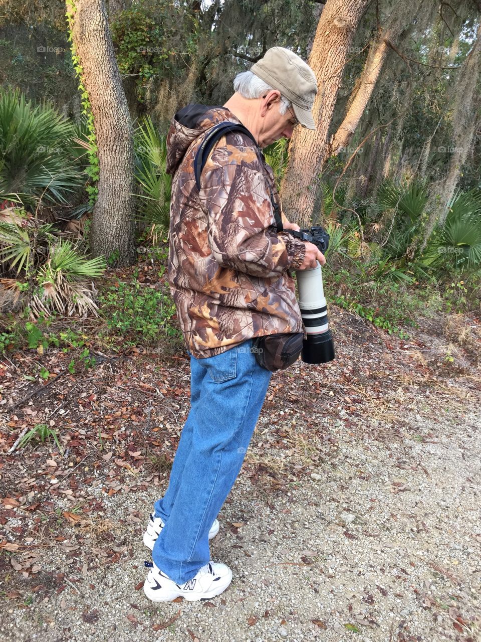 Photographer in his rain jacket and carrying rain gear for his camera and lens in his bag.