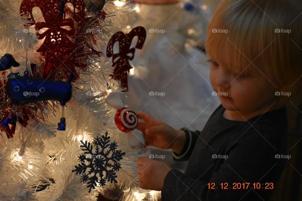 Baby play with the Christmas tree. 