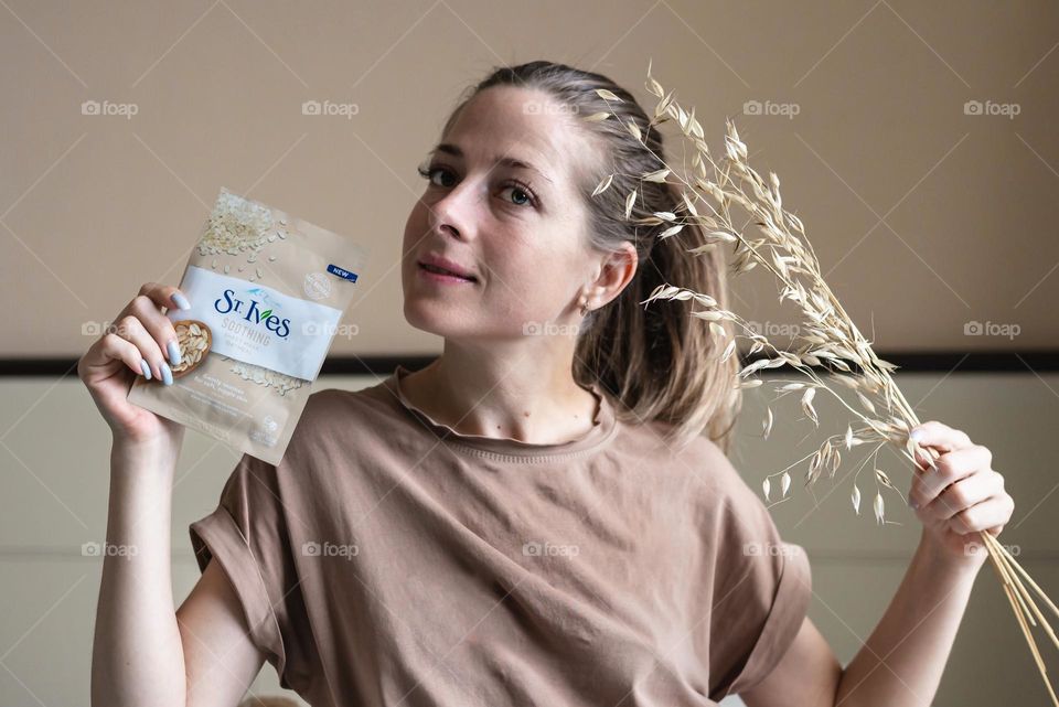 young girl with cosmetics product in her hands, face mask brand St. Ives. Personal care