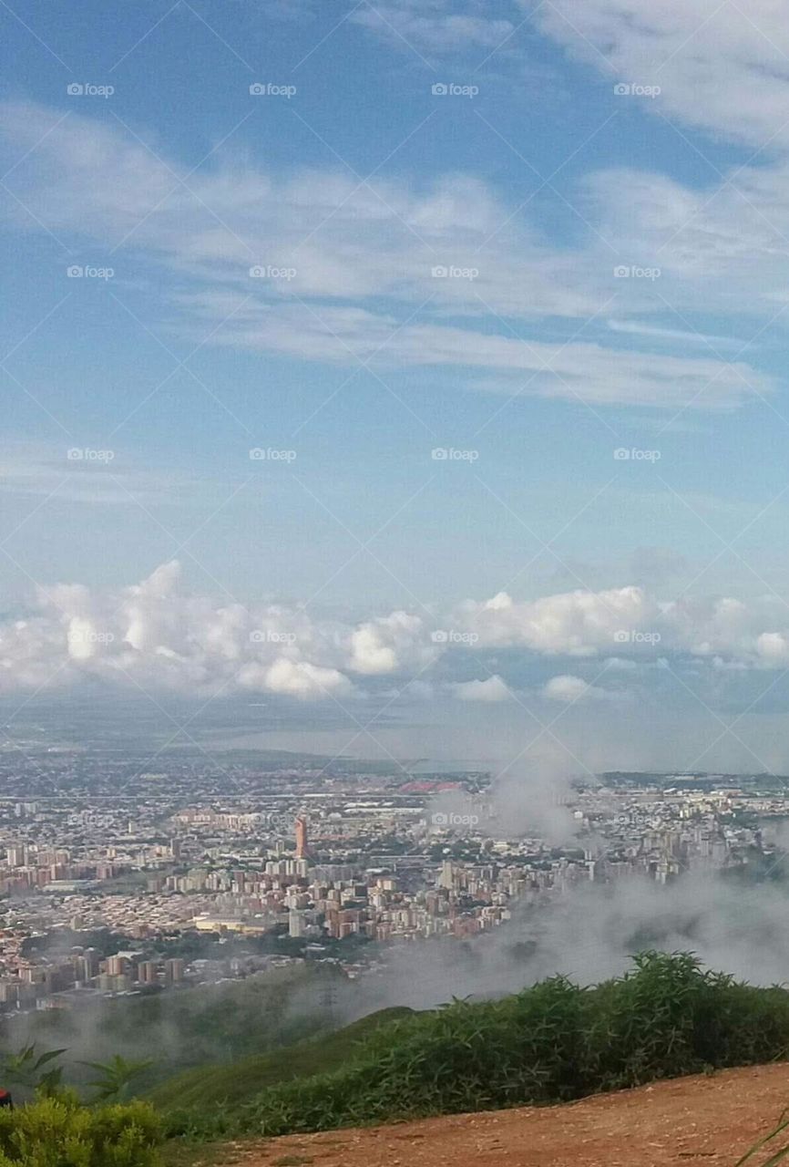 white clouds like tide, blue sky and beautiful landscape where you can see the city