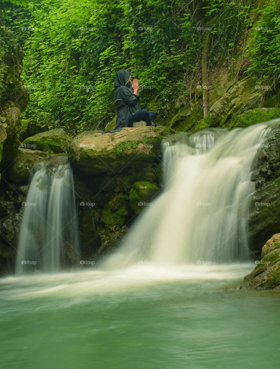 A girl practicing yoga on a waterfall