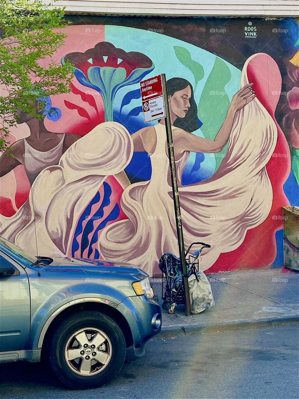Two Hispanic female dancers are twirling in midst their long flowing white gowns as part of a colorful art mural on “Jefferson St” and “Broadway” in “Bushwick”, Bklyn. I am here once again to visit “MG Pharmacy”. 2024. Hypnotic Productions