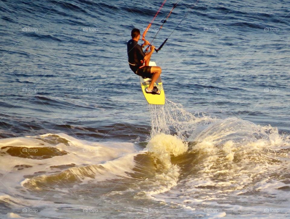 Kite surfer jumping a wave