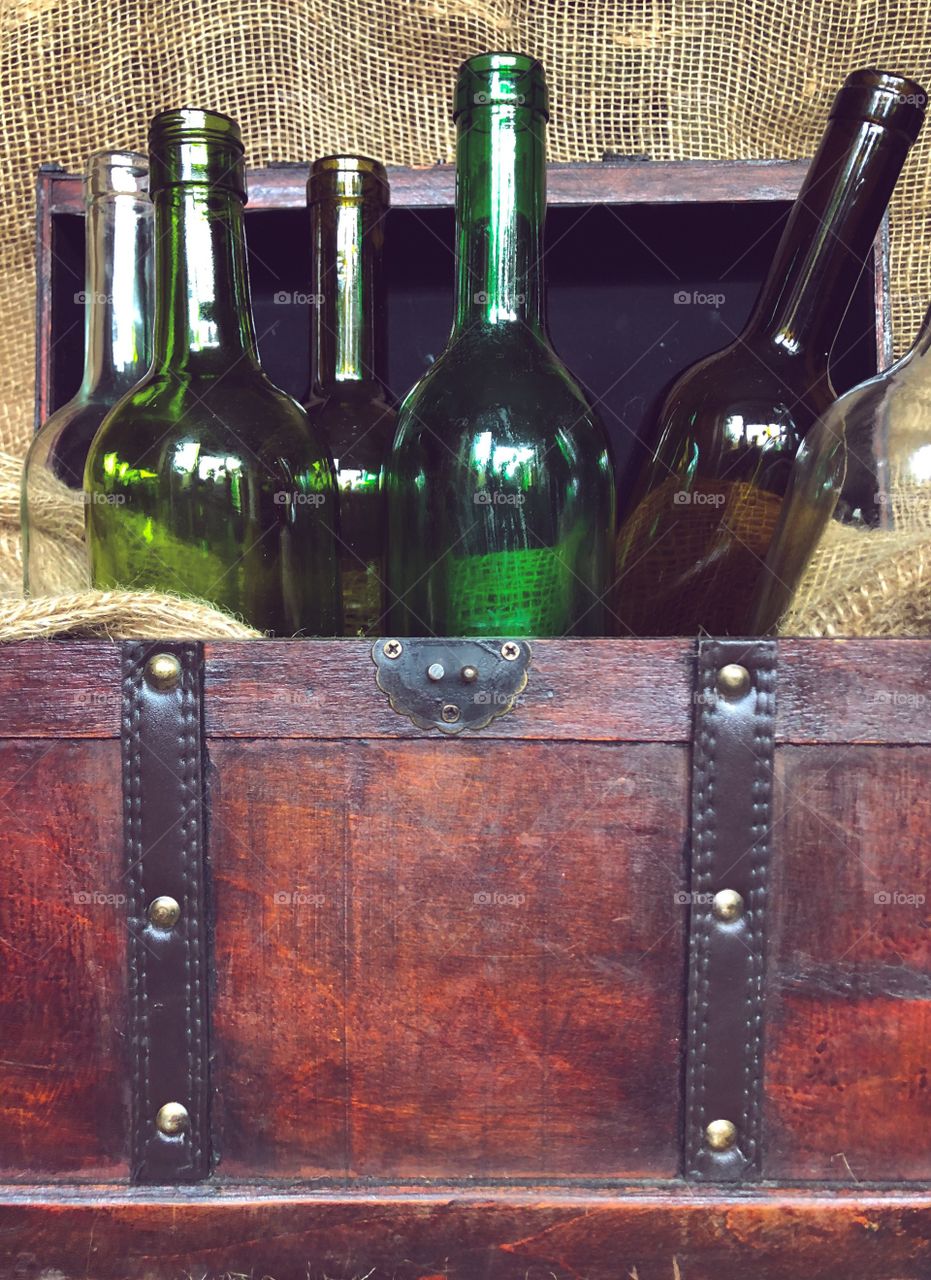 wine bottles in a vintage chest against the background of burlap