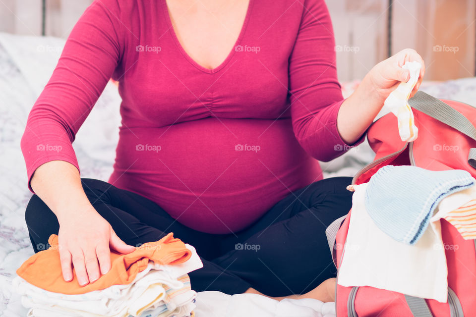 Pregnant woman packing a bag. Pregnant woman packing hospital bag preparing for labor