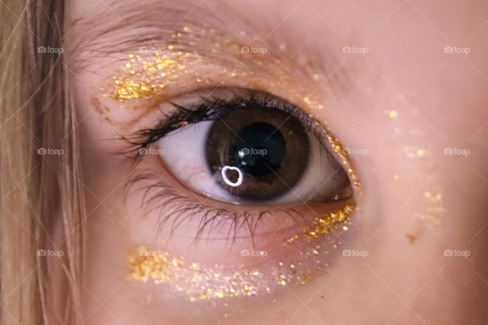 A child wearing glitter makeup