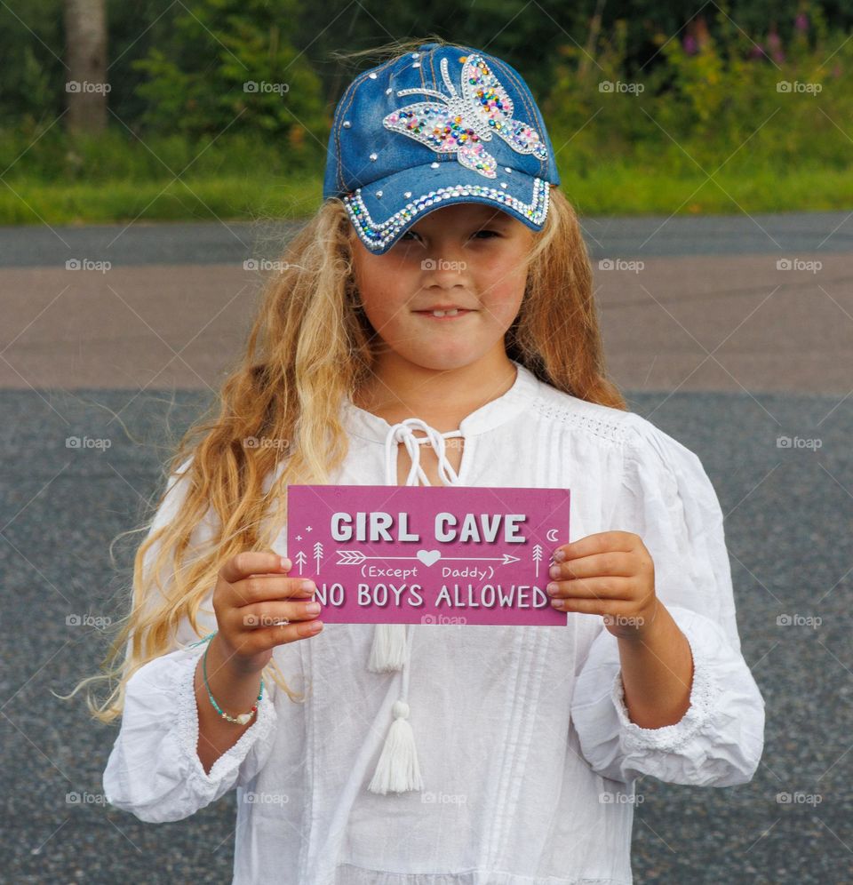 Young girl ,with caps and a some smart words . She is young and bright, and its beautiful light .