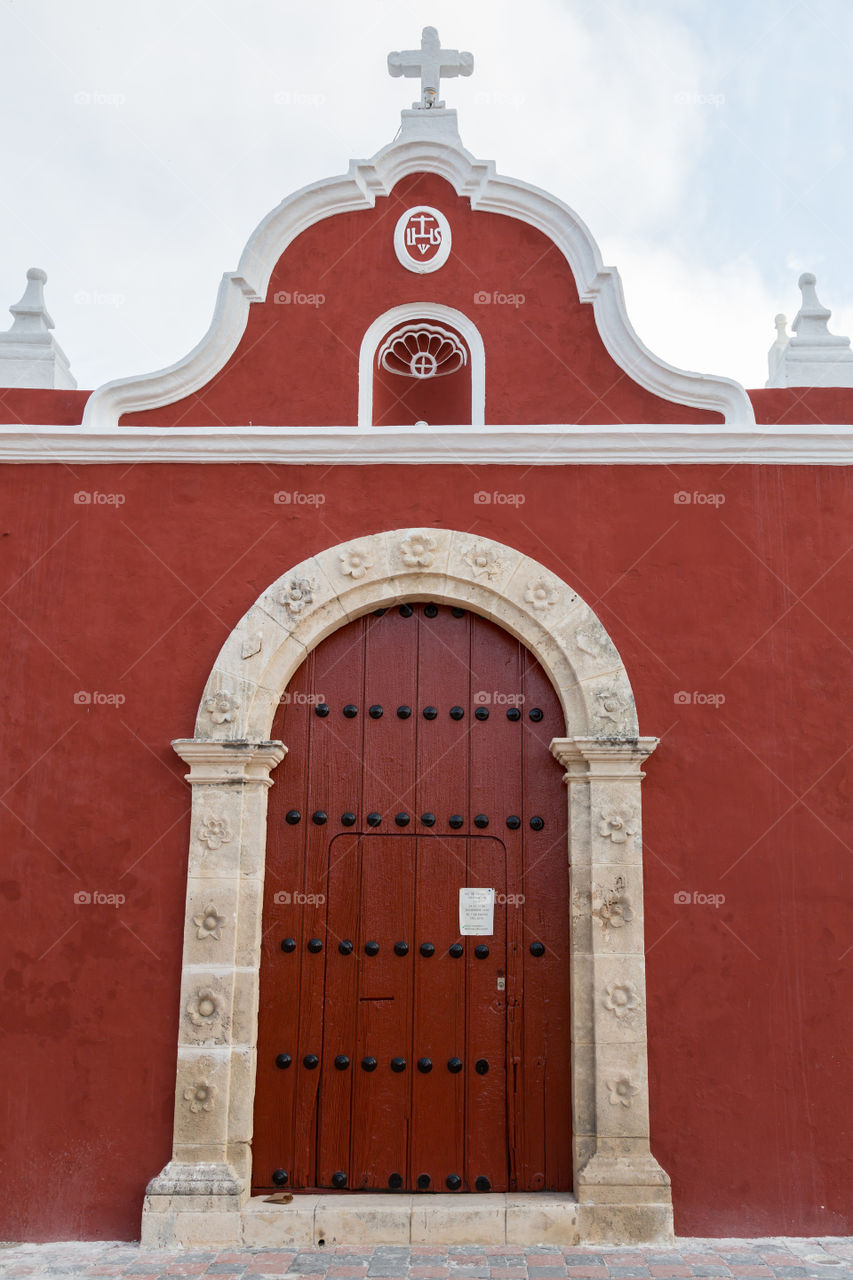 Entrance to the church. Red wooden door to dark red church. Colorful building and decorated door. Historical building