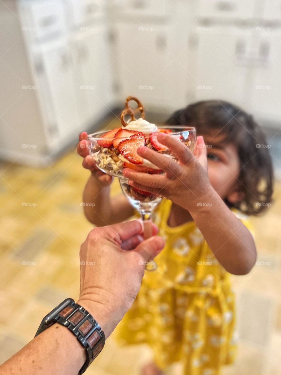 Adult handing child a sweet treat, child reaching for dessert, parent giving dessert to toddler, summertime treats 