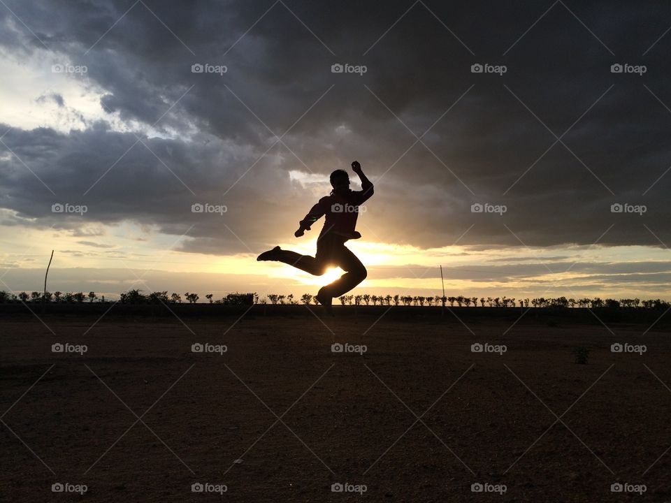 Silhouette of man jumping during sunset