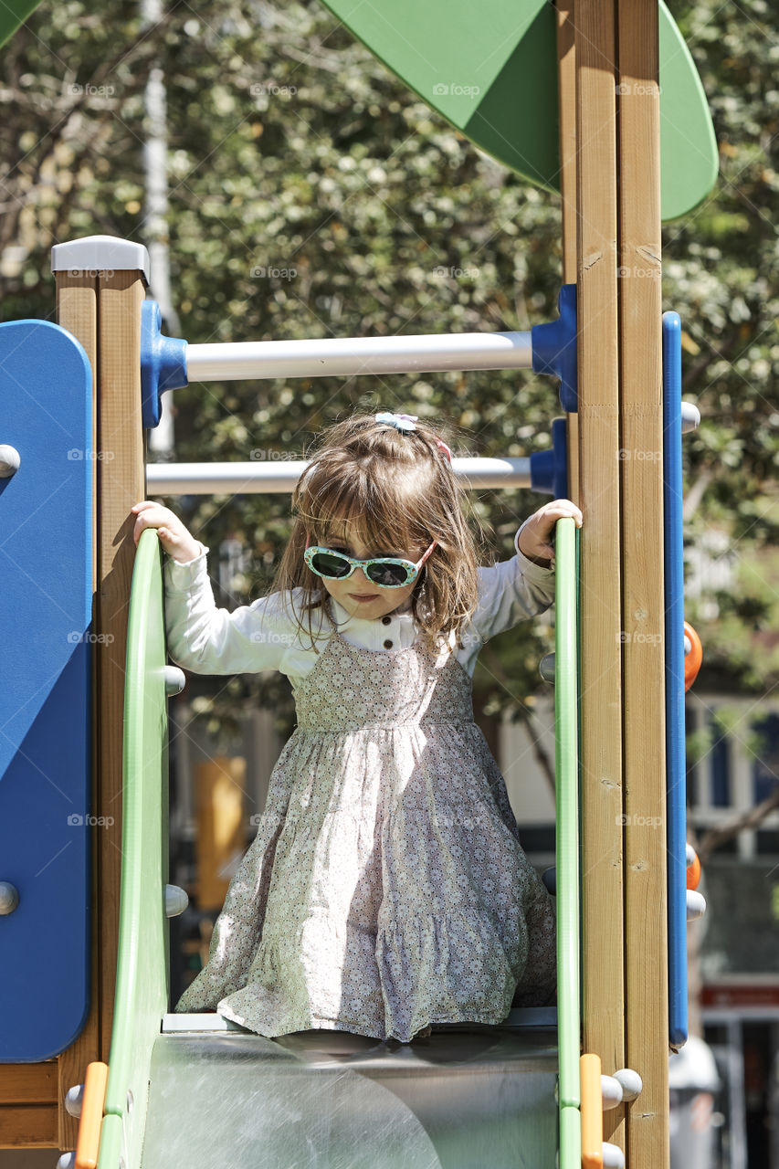 Little Girl wearing sun glasses at the playground