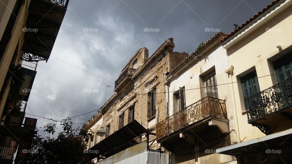 Low angle view of buildings and cloudy skies