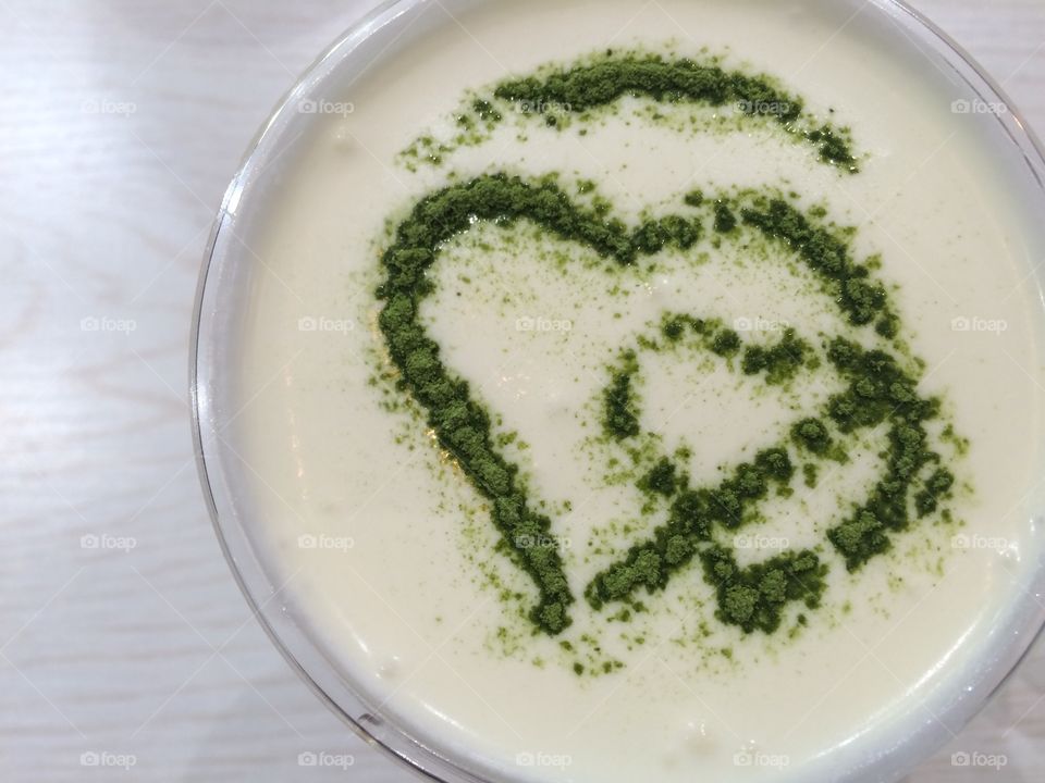 Two green hearts decorating a cheese tea, drink flat lay
