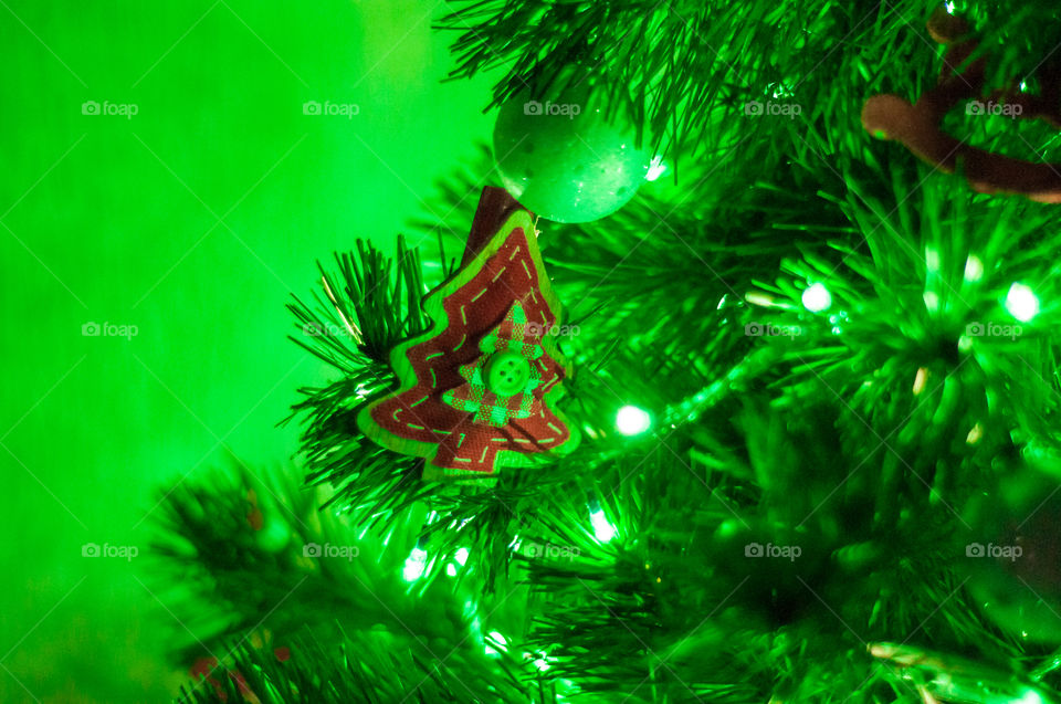 Small wooden Christmas tree around green light 