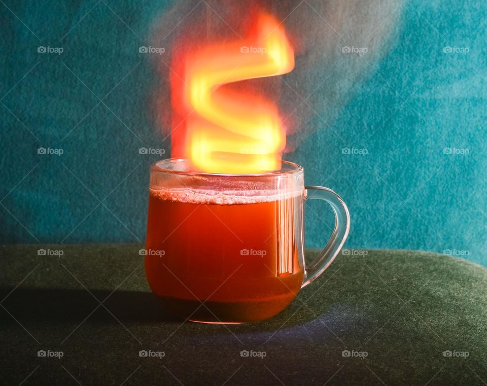 a cup of coffee with a long exposure light effect in the form of orange smoke