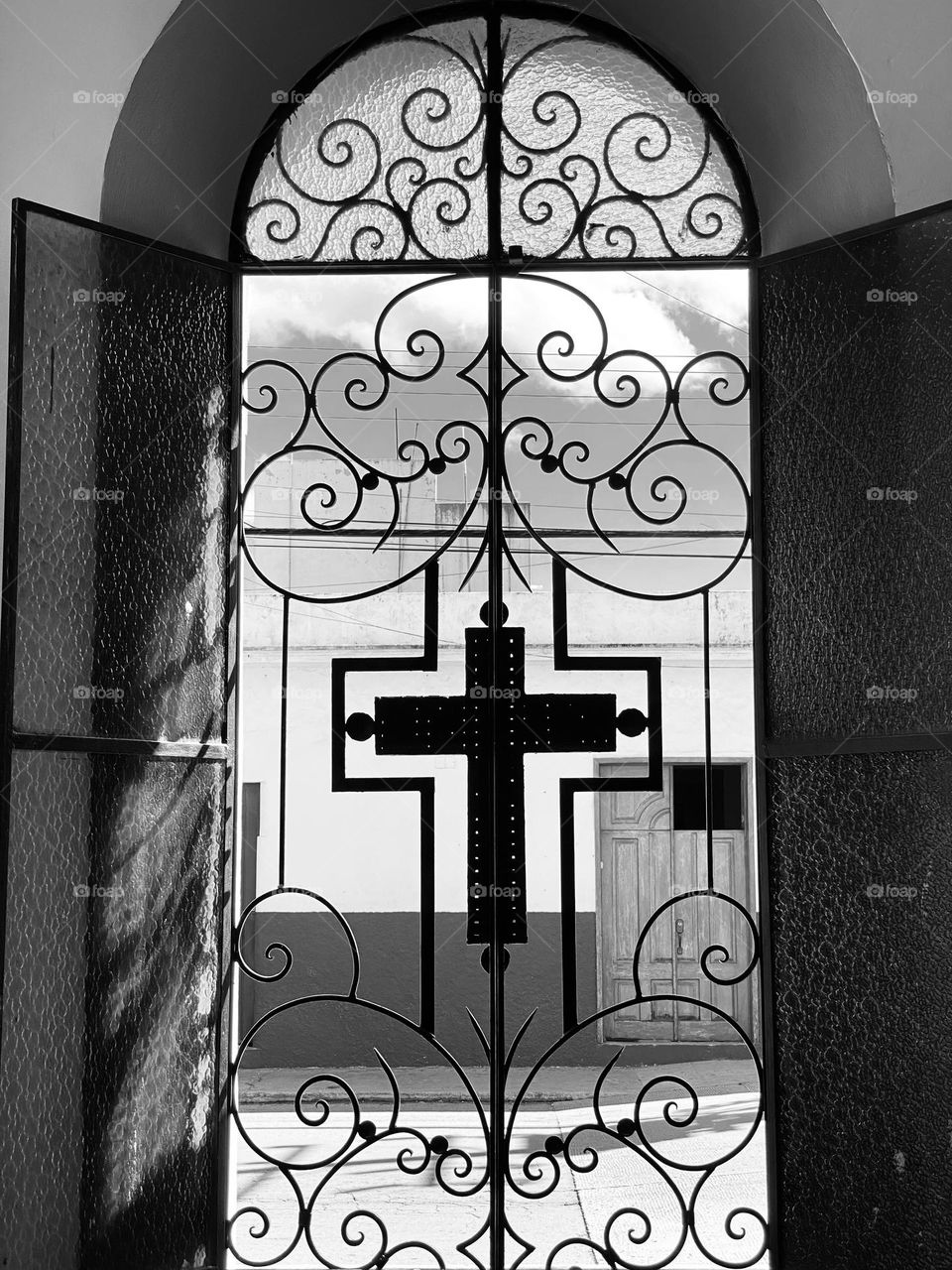 A window with shutters and scrollwork in a church