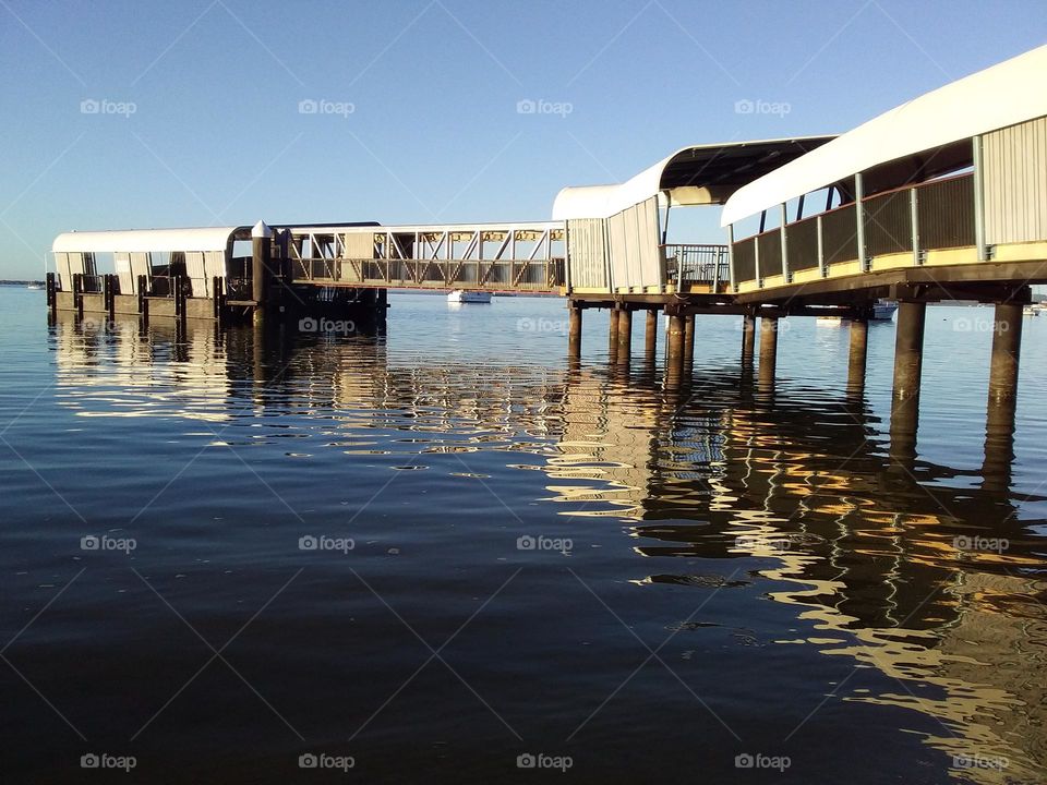 covered jetty reflected in the sea