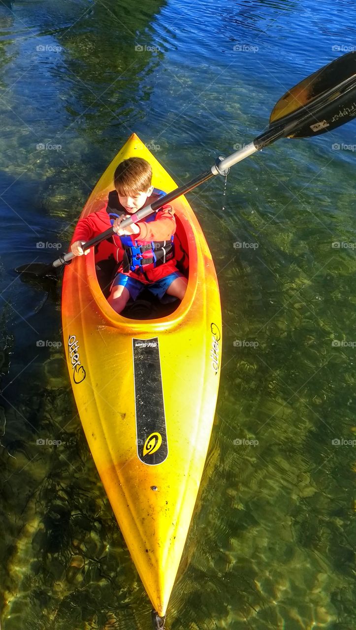 Little boy kayaking on lake