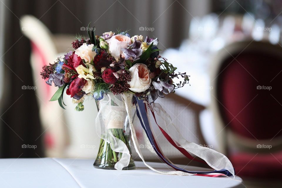 Beautiful wedding bouquet in glass vase on a table.