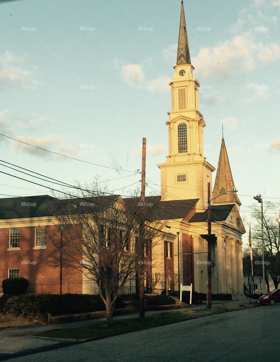 Side and steeple of beautiful church in historic city in the daytime and sky showing.