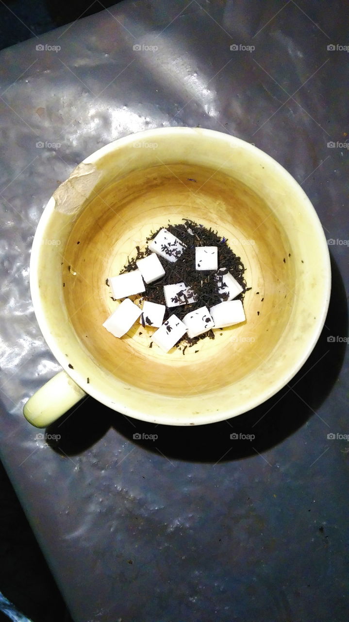 tea leaves of tea and sugar cubes in a cup