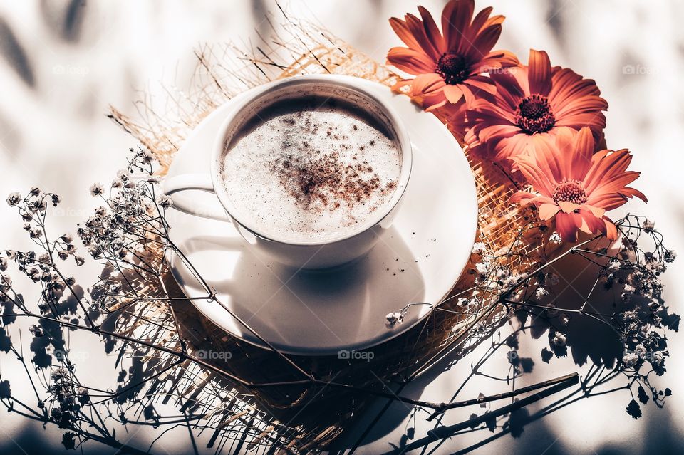 Still life with flowers and cup of cappuccino