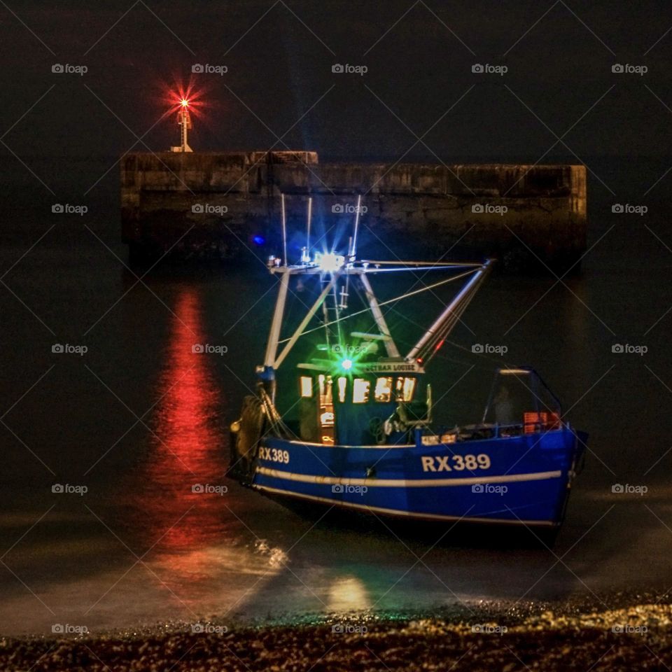 A fishing boat makes its way out to sea for night fishing 