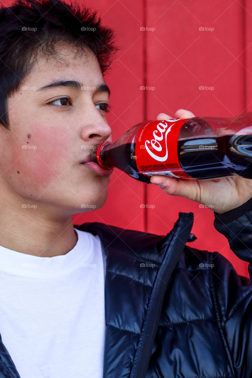 Young handsome man with a bottle of Coca-Cola